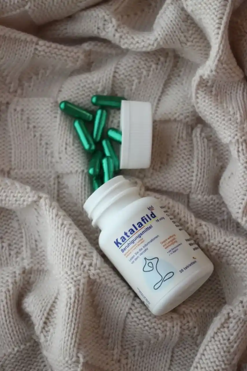 عکس قرص کاتالافیلد دوز 40 میلی گرم روی یک سطح پارچه ای.کپسول های سبز کاتالافیلد دوز 40 روی سطح پارچه ای ریخته شده است